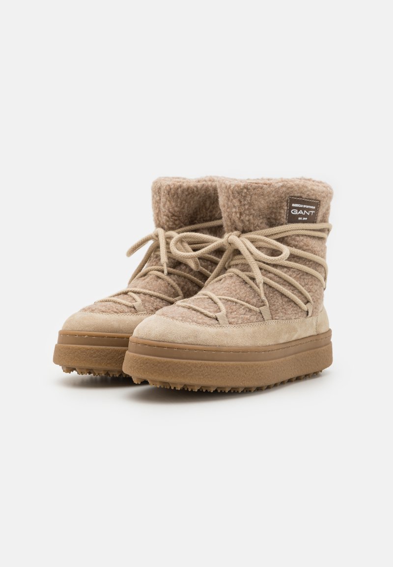 Beige Wildlederstiefel mit einem strukturierten Fleece-Obermaterial und flachen Schnürsenkeln. Dicke Gummisohle mit griffigem Boden für besseren Halt. GANT-Logoschild an der Seite.