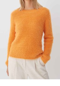Felorange, fluffy trui met lange mouwen en een ronde hals. Zachte textuur en aansluitende snit. Draag hem over lichtgekleurde broeken.