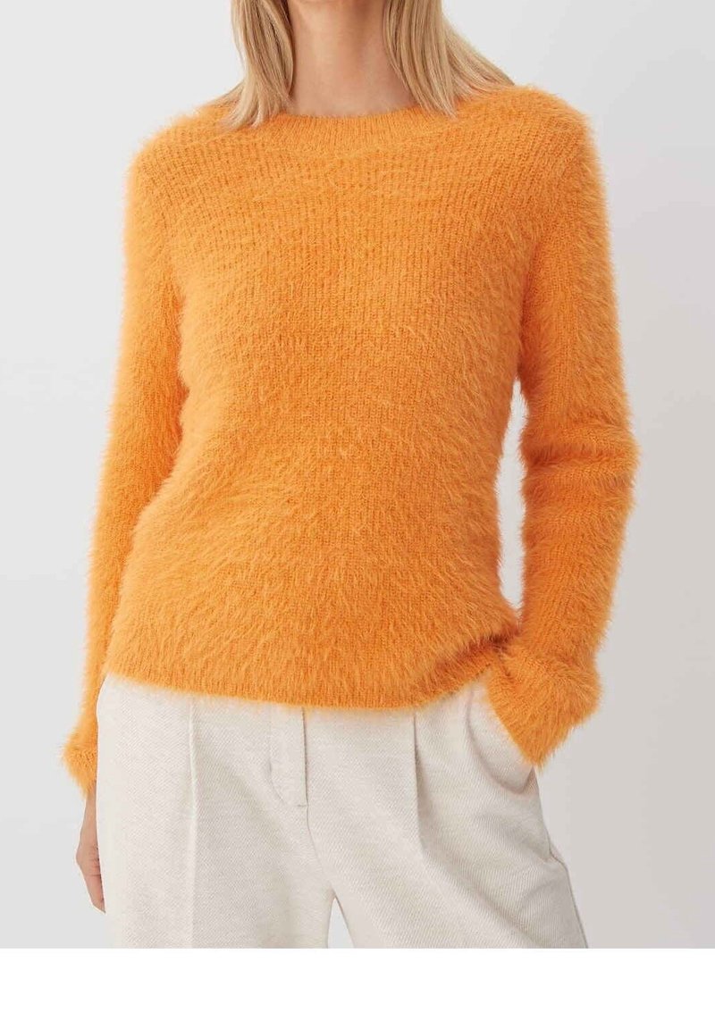 Felorange, fluffy trui met lange mouwen en een ronde hals. Zachte textuur en aansluitende snit. Draag hem over lichtgekleurde broeken.