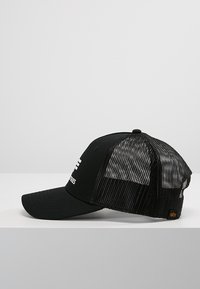 Svart baseballcaps med meshbak, buet skygge og hvit logo. Har justerbar stropp bak for tilpasning av størrelse.