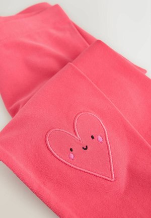 Rózsaszín leggings puha anyagból, szív alakú hímzett mintával, piros arcocskákkal és mosolygó arccal.