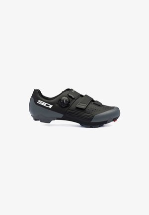 Zapato de ciclismo negro con un diseño aerodinámico, que presenta una parte superior texturizada, dos correas ajustables y una suela robusta con detalles en rojo.