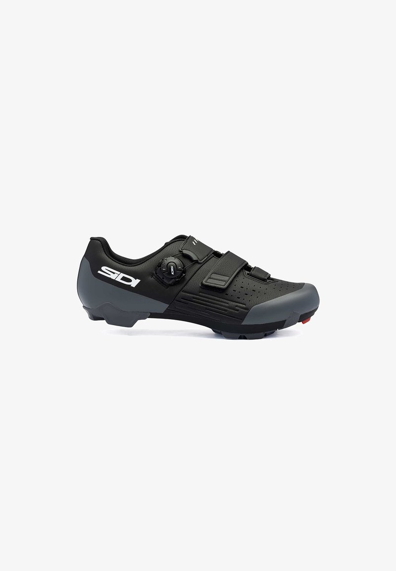 Chaussure de cyclisme noire au design élégant, avec une tige texturée, deux sangles ajustables et une semelle robuste avec des accents rouges.