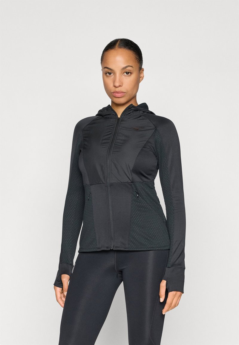 Zwarte zip-up jas met een capuchon en textuurpanelen. Beschikt over duimgaten, afsluitbare zakken en een gladde afwerking op de mouwen.