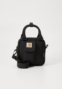 Sac en tissu noir avec deux poignées supérieures, bandoulière ajustable, poche avant à rabat et compartiments zippés. Doté d'un écusson avec logo.