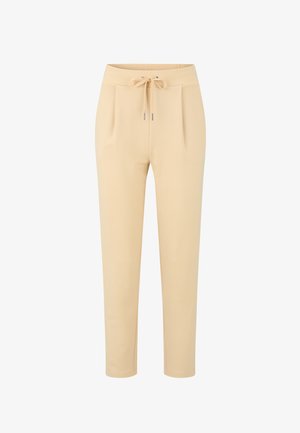 Pantalones de un beige claro con cintura con cordón, pliegues en la parte delantera y piernas ceñidas. Hechos de una tela suave con una textura lisa.