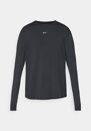 Maglietta a maniche lunghe con scollo rotondo in tessuto grigio scuro con un piccolo logo Nike bianco sul petto e polsini a coste. Tessuto dalla texture liscia.