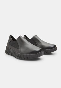 Bottines noires en cuir lisse avec des panneaux élastiques. Dotées d'une semelle en caoutchouc noir texturé avec un motif en vagues pour une meilleure adhérence.