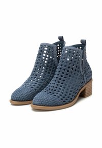 Botines tobilleros de fibra azul con un diseño recortado, con punta afilada y tacón de madera apilada. Tejido texturizado y acentos de hardware mínimos.