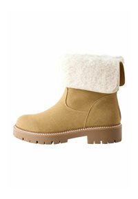 Tan mockask ankle boots med en krämfärgad, fluffig vikbar krage. Tjock gummisula med mönster och dekorerad söm längs kanten.