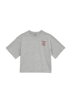 Camiseta gris recortada con mangas cortas y texto rojo "JOVEN Y LIBRE" en el lado superior izquierdo del pecho.