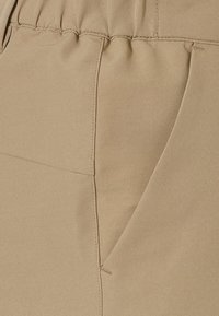 Helles beiges Gewebe mit einer glatten Textur, das über einen gerafften Taillenbund und eine Seitenasche mit dezenten Stickdetails verfügt.