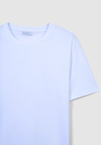 T-shirt in cotone bianco con scollatura rotonda, maniche corte e vestibilità rilassata. Etichetta con la scritta "CALLIOPE", taglia "L" stampata all'interno.