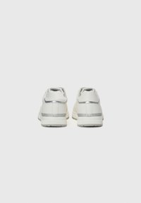 Hvite sneakers med en glatt skinnfasade, grå detaljer og en teksturert hvit såle. Rund hæl og minimalistisk design.