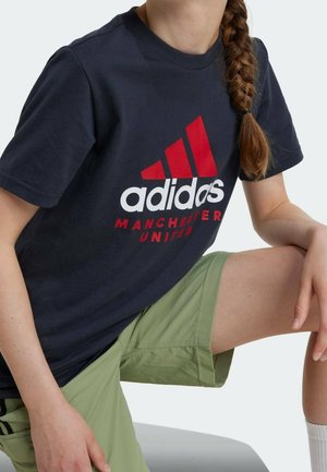 Marineblauw katoenen T-shirt met een groot rood-wit Adidas-logo, gecombineerd met lichtgroene shorts, die een casual, sportief ontwerp laten zien.