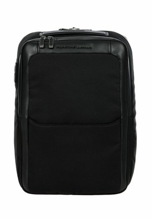 Mochila negra que presenta una combinación de materiales sintéticos lisos y texturizados, cierre con cremallera y un bolsillo frontal. Diseño compacto y rectangular.