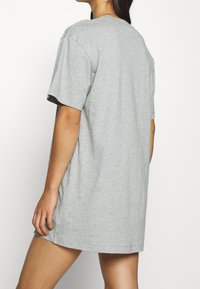 Grå bomulls t-shirt i oversize med korta ärmar, rund halsringning och rak fåll. Synlig sömnad och en avslappnad passform.