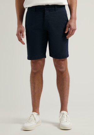 Marineblaue Shorts aus Baumwollmischung, mit einem Knopfverschluss vorne, Gürtelschlaufen und Seitentaschen. Sanfte Textur mit taillierter Passform.