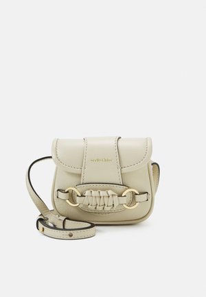 Petit sac bandoulière en cuir beige avec anneaux dorés, détail tressé sur le rabat et bandoulière réglable.