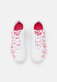 Białe trampki z kolorowym różowym i czerwonym abstrakcyjnym wzorem z boku, o perforowanej teksturze i standardowymi białymi sznurowadłami.