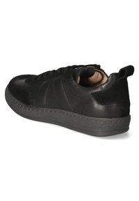 Schwarze Leder-Sneaker mit niedrigem Schnitt, strukturiertem Sohlendesign, Schnürung vorne und Zuglasche an der Ferse, von der Rückseite betrachtet.