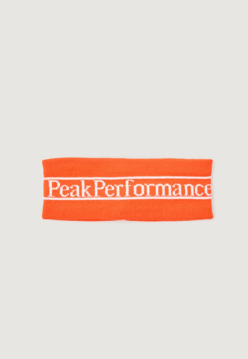 Svetlo oranžna pletena trak na glavi z belo "Peak Performance" blagovno znamko, ki je centrirana na belem traku. Raztegljiv in teksturiran material.