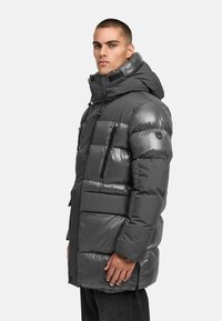 Gray puffer jacket with a shiny finish, featuring a hood, zippered pockets, and a mix of matte and glossy panels.