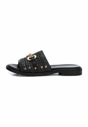 Black open-toe slip-on sandal with woven upper, gold studs, decorative buckle, and low flat heel, photographed on white background.