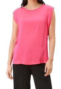 Růžový top s krátkým rukávem vyrobený z měkké tkaniny, kulatým výstřihem a uvolněným střihem. Má čisté okraje a žádné viditelné zavírání.