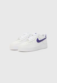 Vita Nike Air Force 1-sneakers har en slät läderöverdela, lila swoosh, perforerad tåbox och en texturerad gummisula.