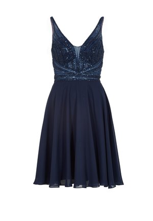 Robe bleu marine avec un corsage ajusté orné de perles et un décolleté en V profond, se transformant en une jupe fluide ; des accents transparents rehaussent le design.