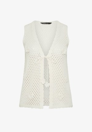 Weißes ärmelloses Häkelweste mit gewellten Rändern, floralen Applikationen und vorderer Knotenverschluss.