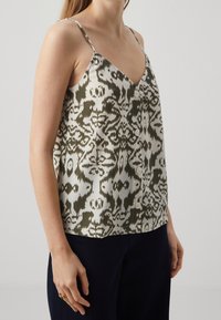 Top senza maniche con scollo a V in un tessuto leggero, caratterizzato da un motivo astratto verde e bianco; presenta dei dettagli con bottoni lungo la parte anteriore.