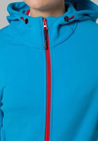 Blauwe hoodie met een hoge kraag, rode rits en accenten, gemaakt van een gladde, elastische stof. Heeft trekkoordverstellingen aan de capuchon.