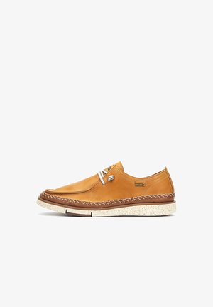 Chaussures en cuir marron avec une finition lisse, semelle blanche contrastante et couture décorative. Comprend des œillets et des lacets pour un ajustement sécurisé.