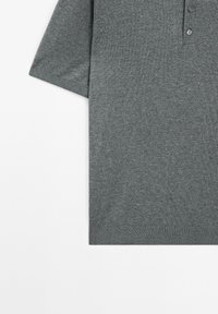 Polo grigio a maniche corte realizzato in morbido misto cotone, con colletto a costine e chiusura a tre bottoni, privo di fantasie visibili.