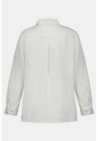 Camicia bianca in lino a maniche lunghe con yoke posteriore, colletto a revers e polsini con bottone. Presenta un design semplice senza motivi o decorazioni.