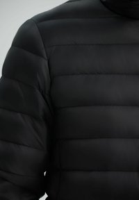 Black puffer jacket featuring horizontal quilted panels, smooth texture, high collar, and no visible hardware or accents.