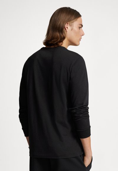 Svart langermet t-skjorte laget av mykt stoff, med avslappet passform og rund hals. Ermene har smale mansjetter, ingen synlige mønstre.