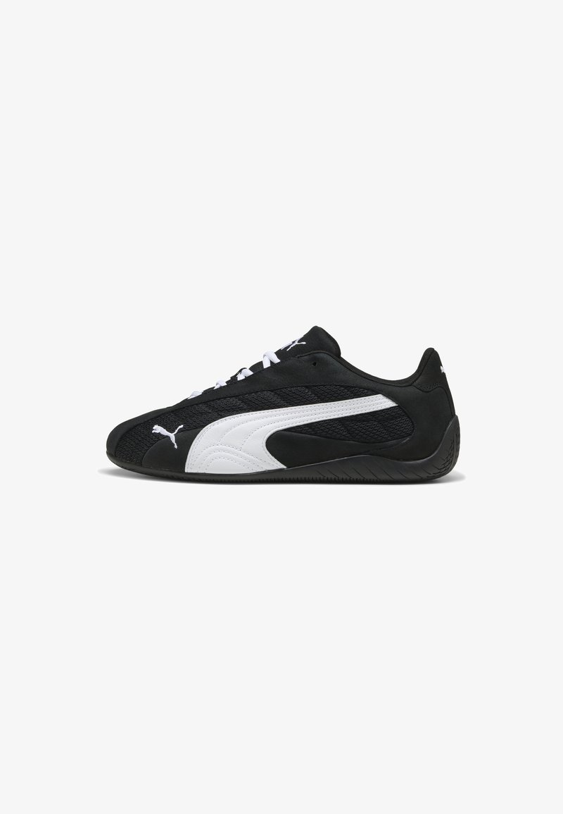 Schwarz-weiße Sportschuhe mit einem Obermaterial aus Mesh und Wildleder, Schnürverschluss und strukturierten Gummisohlen mit dem auffälligen PUMA-Logo.