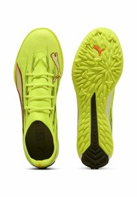 Neongule træningssko med en struktureret mesh-overdel, sorte og røde accenter samt en mønstret gummiydersål designet til greb.