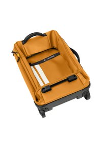 Una valigia rotolante in tessuto giallo senape con un interno nero, dotata di una maniglia superiore, tasche con cerniera e dettagli a strisce bianche.