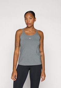 Grå treningssinglet med tynne stropper og rund hals. Har en liten hvit Nike-logo på brystet. Slim-fit design.