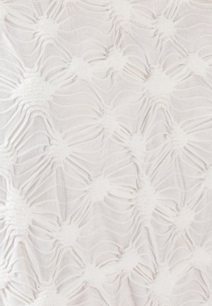 Tejido blanco texturizado con un patrón ondulado y elevado. Pequeños acentos esponjosos crean un contraste táctil, realzando el interés visual del material.
