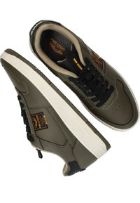 Baskets en cuir vert avec une finition texturée, lacets noirs, semelle blanche et accents de logo. Présente des perforations dans la zone des orteils.