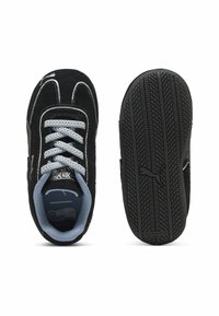 Adidași din piele intoarsă neagră cu șireturi gri, având un interior albastru și o talpă de cauciuc distinctivă cu un model texturat, care nu lasă urme.