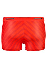 Maillots de bain rouges avec un motif de rayures diagonales, fabriqués en matériau élastique avec une taille à cordon de serrage et des coutures plates.