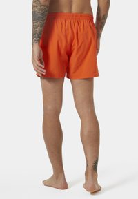 Pantaloni da bagno arancioni con vita elastica, dal design semplice e dalla lunghezza corta, che mostrano una texture liscia e un colore vivace.