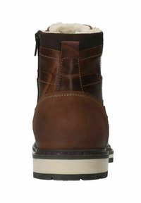 Stivaletto in pelle marrone con fodera morbida. Caratterizzato da una cerniera laterale e un tacco testurizzato. Suola robusta in gomma con un accento bianco.