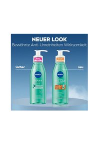 Two transparent green pump bottles labeled "NIVEA DERMA SKIN CLEAR." Left bottle features a pink label; right bottle has an orange label.